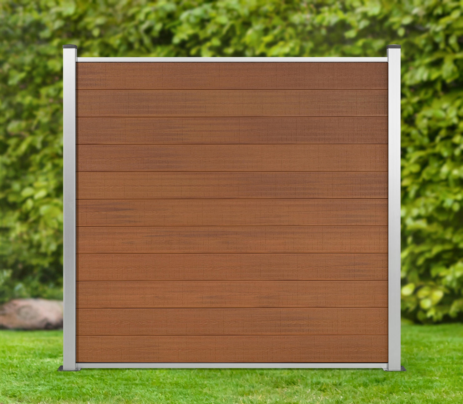 WPC Sichtschutzzaun Eleganz hellbraun steht in einem grünen Garten, dahinter eine grüne Hecke 